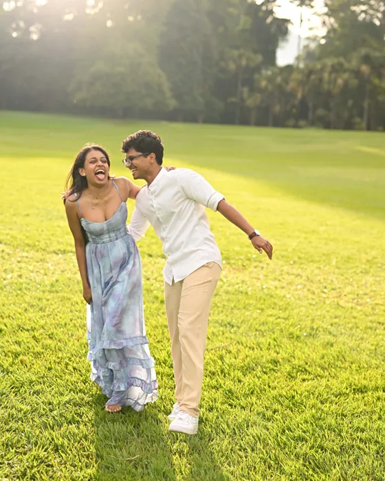 Nishara and Devon laughing together on a sunlit lawn